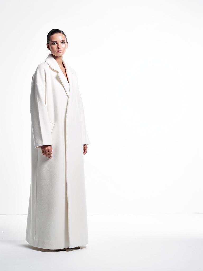 Manteau long blanc photographié en studio sur fond blanc.